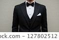 Close-Up of Man Wearing Elegant Black Tuxedo and Bow Tie with White Pocket Square 127802512