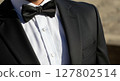 Close-Up of Elegant Black Tuxedo and Bow Tie in Sunlight 127802514