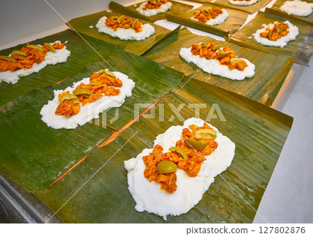 Tamale preparation Mexican recipe banana leaves 127802876