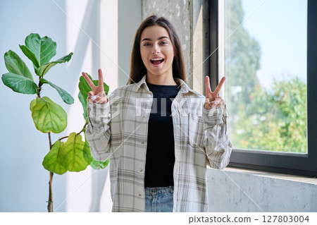 Happy emotional teenage girl showing victory gesture 127803004