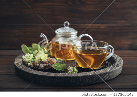 Glass cup of linden tea with glass teapot Glass cup of linden tea with glass teapot 127803142
