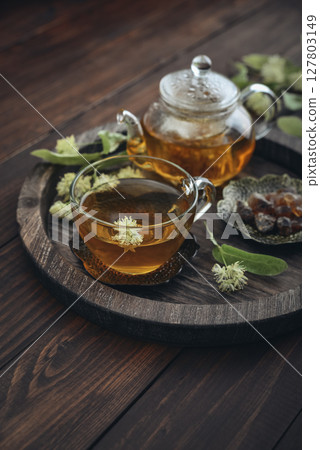 Glass cup of linden tea with glass teapot Glass cup of linden tea with glass teapot 127803149