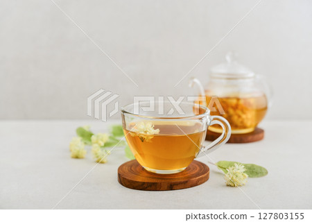 Glass cup of linden tea with glass teapot Glass cup of linden tea with glass teapot 127803155