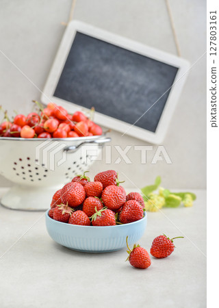 Strawberry and sweet cherry with framed chalkboard Strawberry and sweet cherry with framed chalkboard 127803161