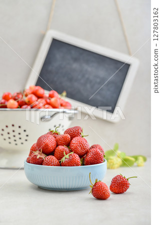 Strawberry and sweet cherry with framed chalkboard 127803162