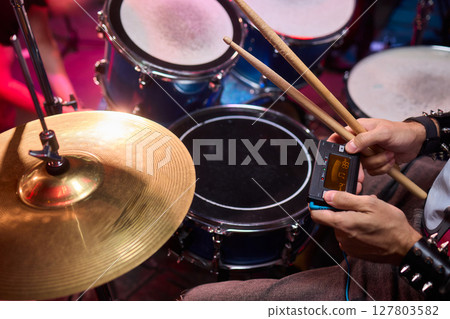 Dynamic Drummer Vibrantly Playing at a Live Music Event with High Energy and Excitement 127803582