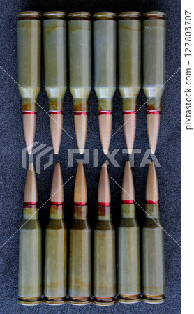 Top view of twelve bullets in two groups lined up head to head on clean black fabric. Stock Photo For Vertical Bullets Backgrounds Top view of twelve bullets in two groups lined up head to head on clean black fabric. Stock Photo For Vertical Bullets Backgrounds 127803707