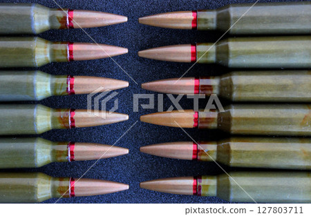 Pattern of live ammunition laid out bullet to bullet on a black background detailed stock photo 127803711