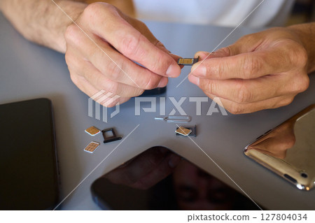 Detailed Process of Installing a SIM Card Utilizing Various Smartphone Components and Accessories 127804034