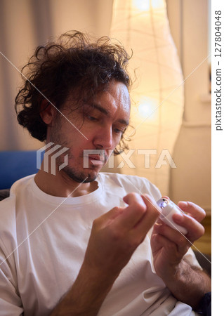 Close-up of an electric nail clipper in hand, modern personal care technology, highlighting compact design and functionality, modern gadget for personal grooming 127804048