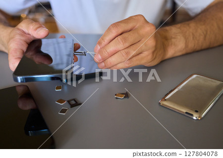 Detailed Process of Installing a SIM Card Utilizing Various Smartphone Components and Accessories 127804078