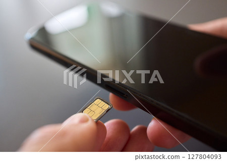 Detailed Process of Installing a SIM Card Utilizing Various Smartphone Components and Accessories 127804093