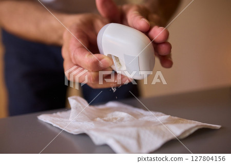 Close-up of an electric nail clipper in hand, modern personal care technology, highlighting compact design and functionality, modern gadget for personal grooming 127804156