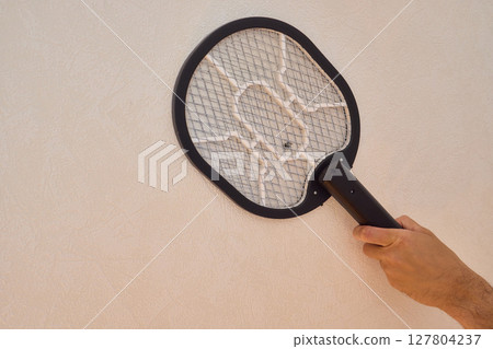 Electric mosquito swatter gray color minimal style placed on white background in bedroom Electric mosquito swatter gray color minimal style placed on white background in bedroom 127804237