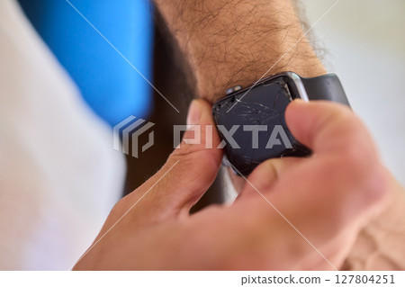 Closeup view of a Smartwatch resting on a Wrist featuring noticeable Scratches and marks 127804251