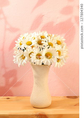 Beautiful daisy flowers in vase on elegant modern background, spring and summer product advertising banner, abstract floral arrangement, holiday greeting card with space for text Beautiful daisy flowers in vase on elegant modern background, spring and summer product advertising banner, abstract floral arrangement, holiday greeting card with space for text 127804340
