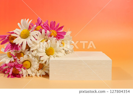 Empty podium with beautiful flowers of garden chamomile and mallow.Abstract flower arrangement,banner.Creative template for your design.Minimal modern aesthetics, elegant beauty concept 127804354