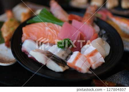 Close-up shot of raw fish sashimi with rose petals and garnish Close-up shot of raw fish sashimi with rose petals and garnish 127804807