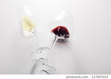Little red, white wine is poured into stem glasses. 127805025