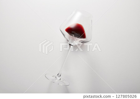 Red wine is inside stemware isolated on light gray. Red wine is inside stemware isolated on light gray. 127805026