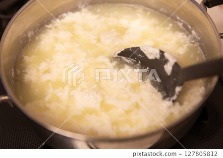 Milk whey in a pot heated with vinegar and separated 127805812