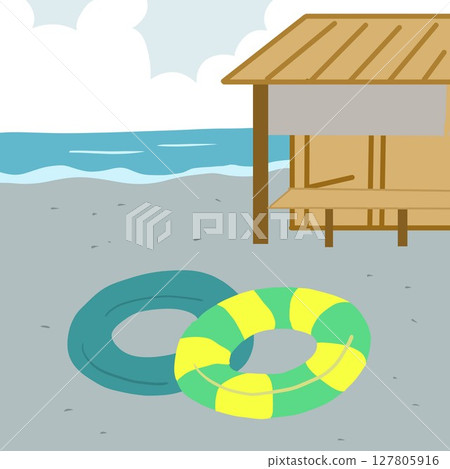 A sandy beach lined with beach huts and swim rings A sandy beach lined with beach huts and swim rings 127805916