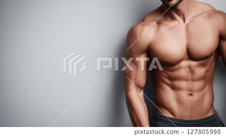Toned male body showcasing strength and fitness in a neutral background setting with copy space 127805998