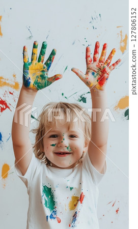 Smiling preschooler showing colorful painted hands after creating artwork at school, enjoying creative activities and early childhood education 127806152