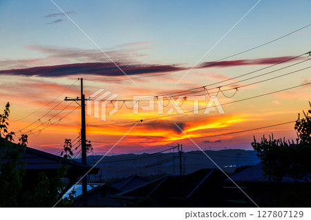 Beautiful sunset after the rain. Golden clouds piled up like millefeuille on the mountainside after sunset. 127807129