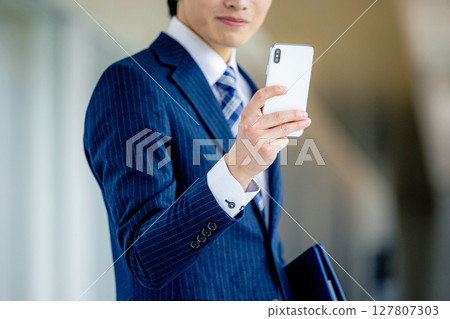 操作智能手機的商人在辦公室 127807303