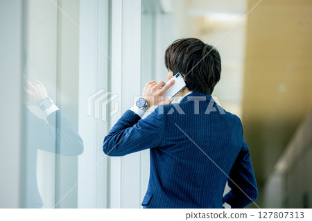 Businessman talking on a smartphone Businessman talking on a smartphone 127807313