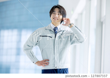 一個年輕人在衣服上工作 127807337