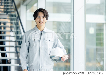A young man wearing work clothes A young man wearing work clothes 127807342