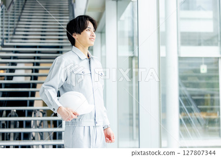 一個年輕人穿著工作服 127807344