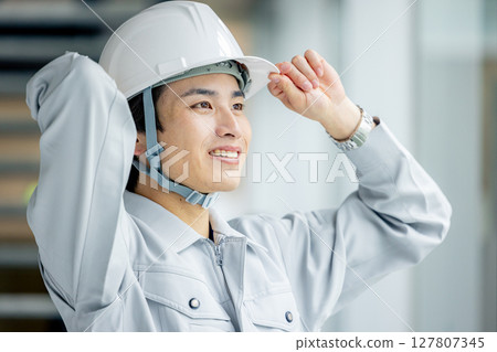 一個年輕人穿著工作服 127807345