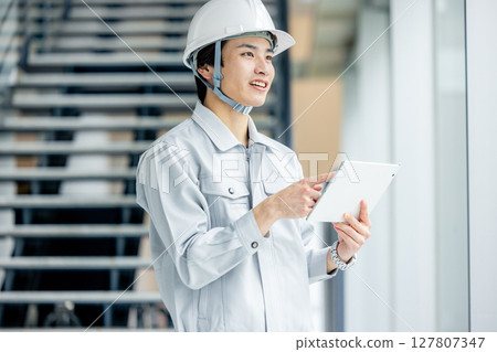 Young worker in work clothes standing in the office corridor 127807347