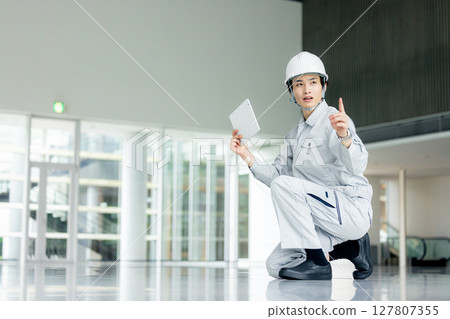 Young worker in work clothes standing in the office corridor 127807355