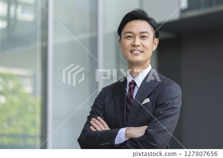 Middle-aged businessman with arms folded, looking at camera 127807656