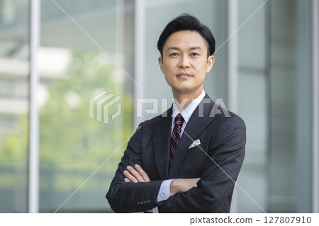 一位 40 多歲的商人抱著雙臂看著鏡頭 127807910