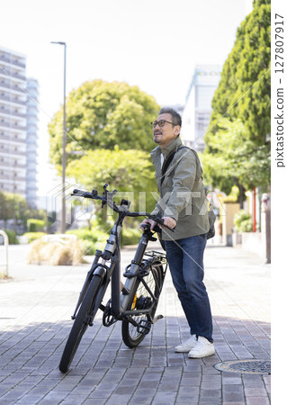 A man in his late 50s riding a bicycle A man in his late 50s riding a bicycle 127807917