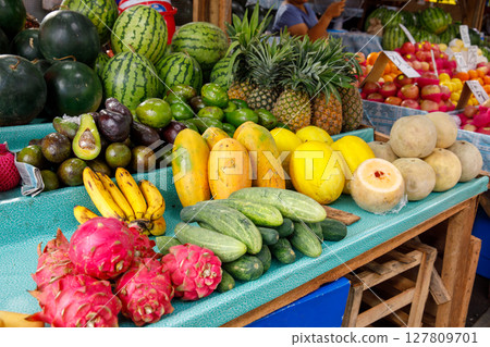 Tropical fruits including watermelon, pineapple, papaya, dragon fruit, and cucumbers at market stall in Philippines 127809701