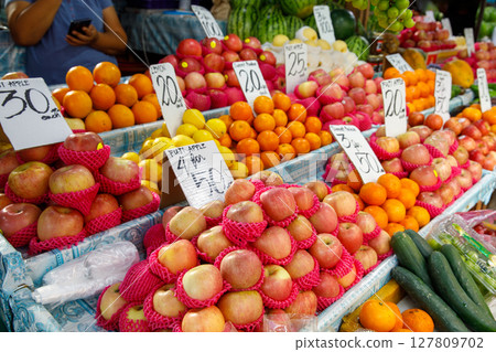 Apples, oranges, lemons, and cucumbers displayed at fruit and vegetable market stall in Philippines with price signs Apples, oranges, lemons, and cucumbers displayed at fruit and vegetable market stall in Philippines with price signs 127809702