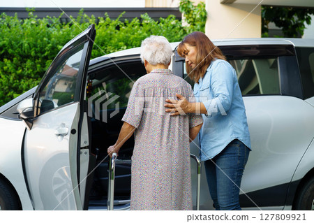 Caregiver help Asian elderly woman disability patient use walker to get in car. Caregiver help Asian elderly woman disability patient use walker to get in car. 127809921