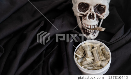 Skull Chewing Tobacco on Black Cloth. Skull Chewing Tobacco on Black Cloth. 127810443