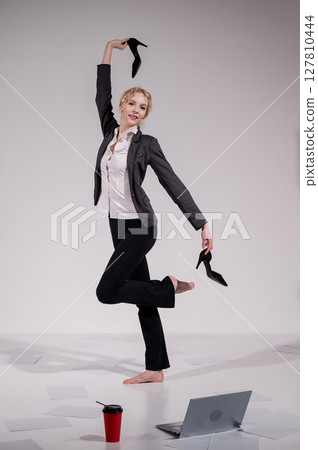 Barefoot ballerina dancing in business suit on white background. Barefoot ballerina dancing in business suit on white background. 127810444