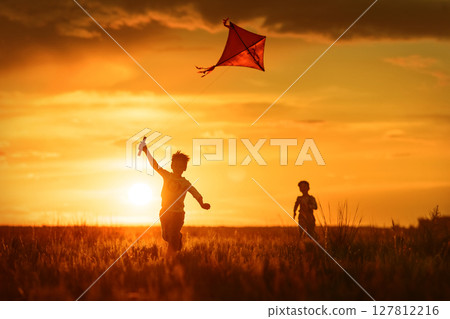 Children with a kite at sunset 127812216