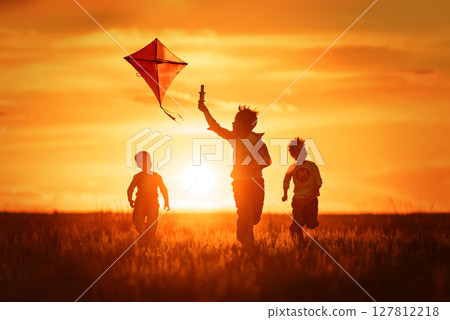 Children with a kite at sunset Children with a kite at sunset 127812218