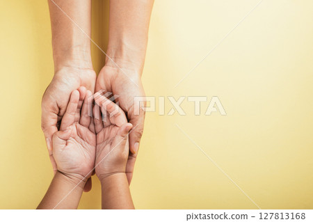 Top view of family hands stacked isolated background. Parents and child holding empty space a gesture of support and love on Family and Parents Day. Concept of togetherness and trust. 127813168