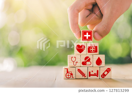 Hand arranged wooden blocks with icons of medical health. health insurance for your health concept. Healthcare medical business. Hand arranged wooden blocks with icons of medical health. health insurance for your health concept. Healthcare medical business. 127813299