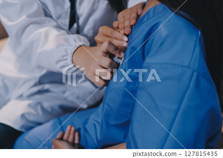 A doctor uses a stethoscope to check the heartbeat of his patient. Patients must undergo a yearly check-up for their health or a check-up from a cardiologist. 127815435